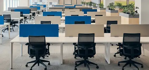 Modern open-plan office space featuring clean workstations, ergonomic chairs, and sanitized carpets provided by professional office cleaning services in Denver, CO.