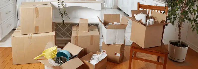 Packed moving boxes and household items in a kitchen before move-out or move-in cleaning, Denver, CO.